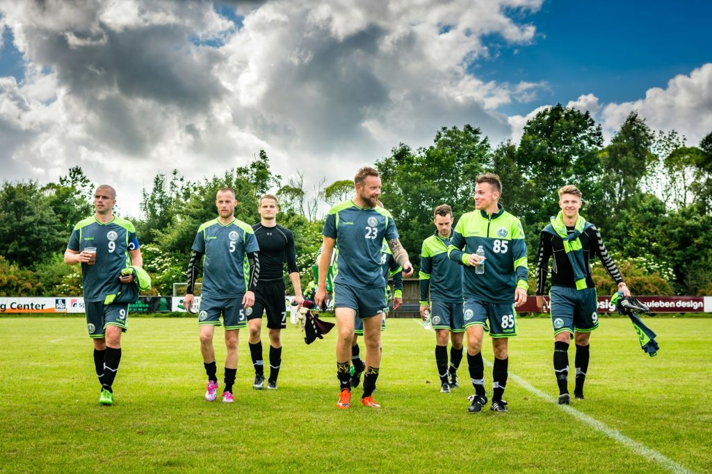 Équipe de foot amateur qui marche sur le terrain après un match