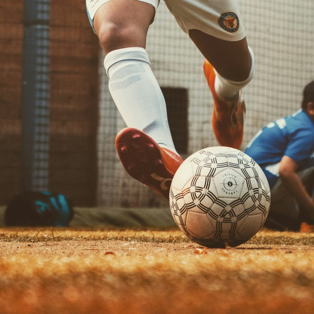 Joueur amateur qui frappe le ballon sur un terrain de foot à 5